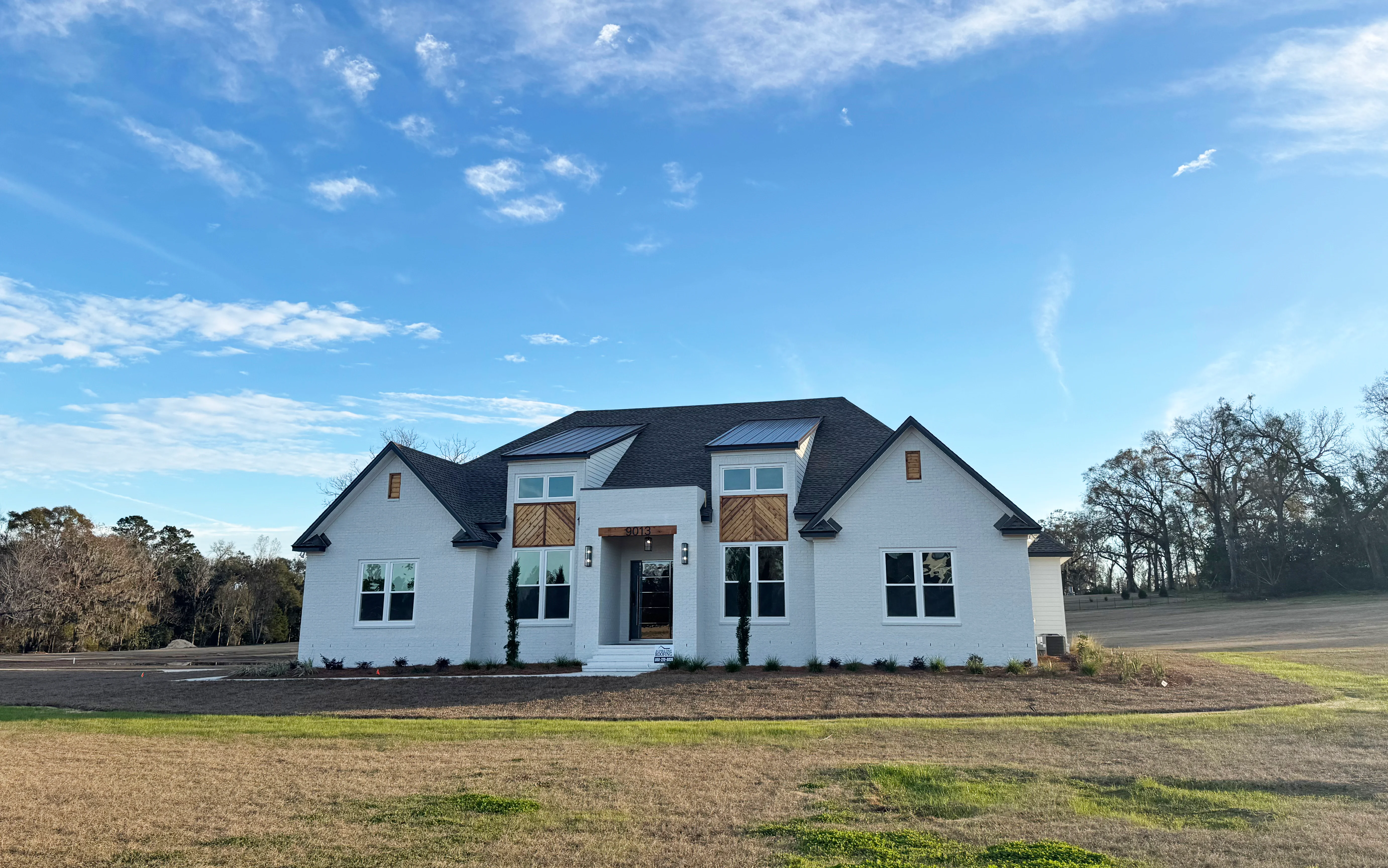 New dark gray asphalt shingle roof on white modern residential home in Tallahassee
