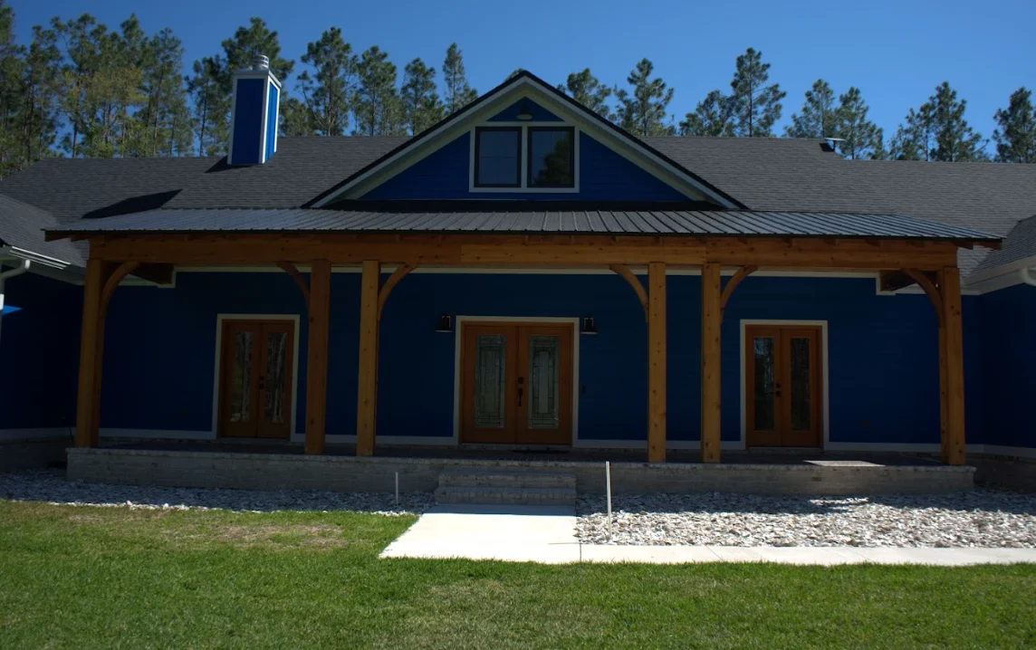 Modern home with new gray asphalt shingle roof and metal porch roof accents