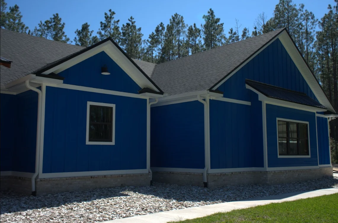 New gray architectural shingle roof on blue residential home with dual gables