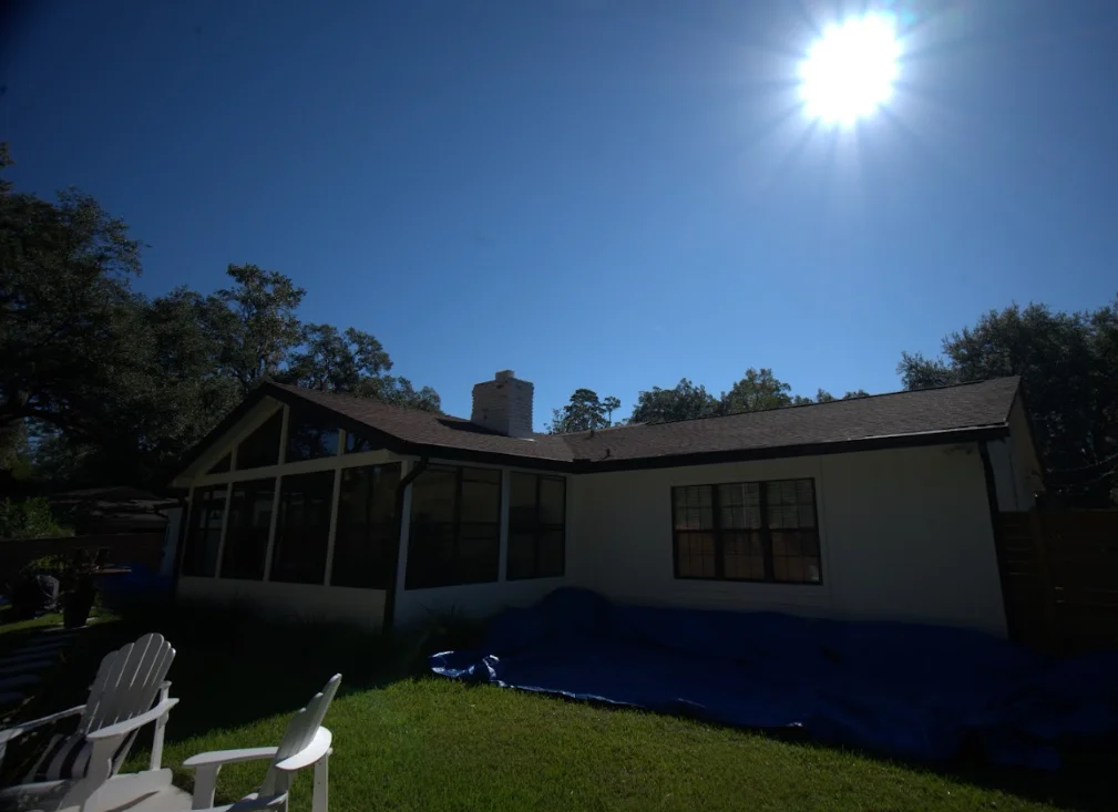 Single-story home with newly installed asphalt shingle roof and brick chimney