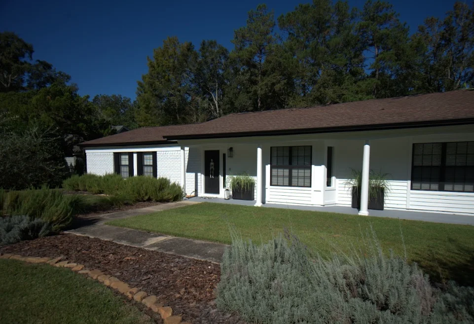 Single-story home with new brown roof, white siding, and black-trimmed windows in Tallahassee