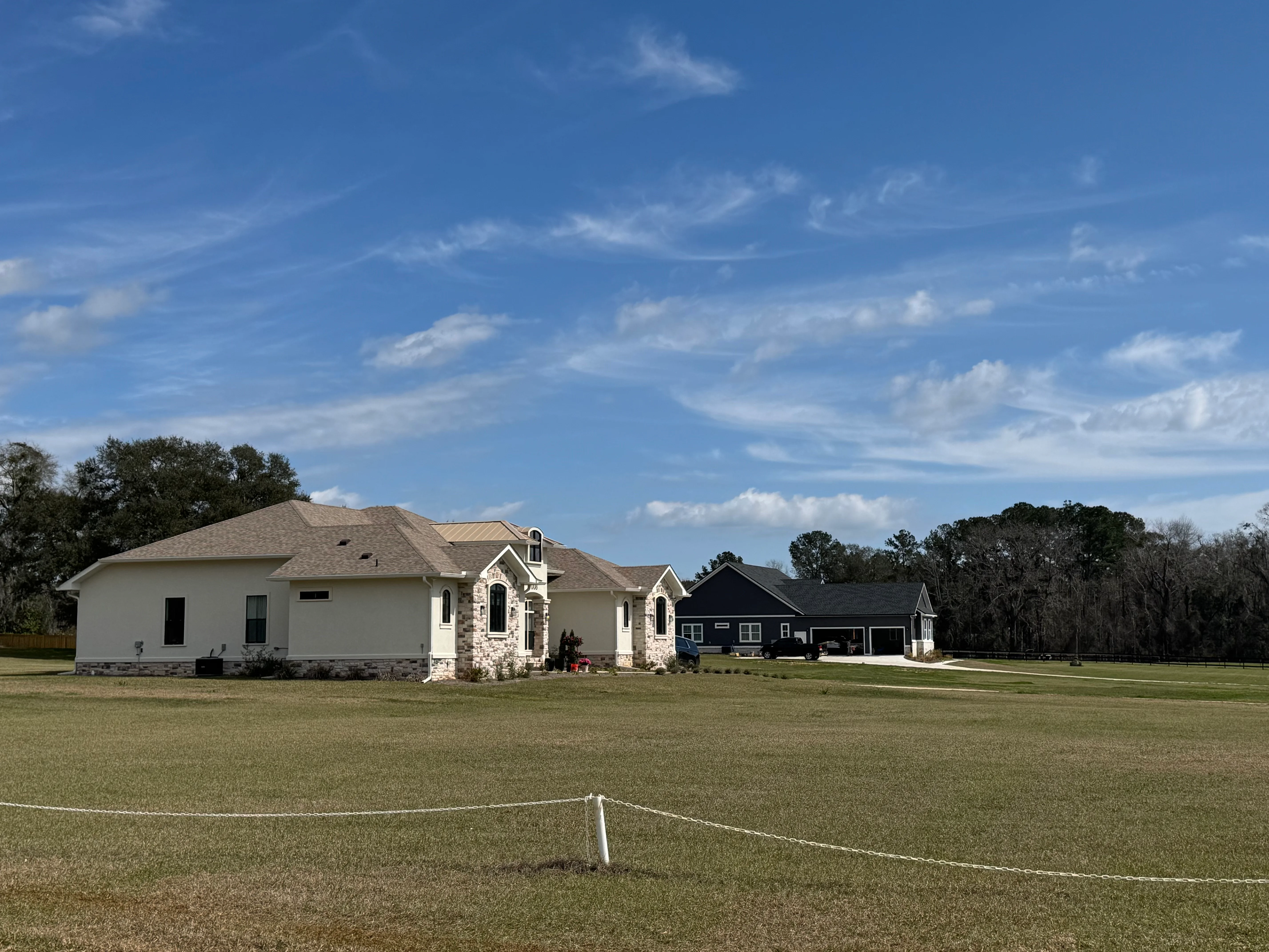 New residential home with installed architectural shingle roof in tan and gray tones