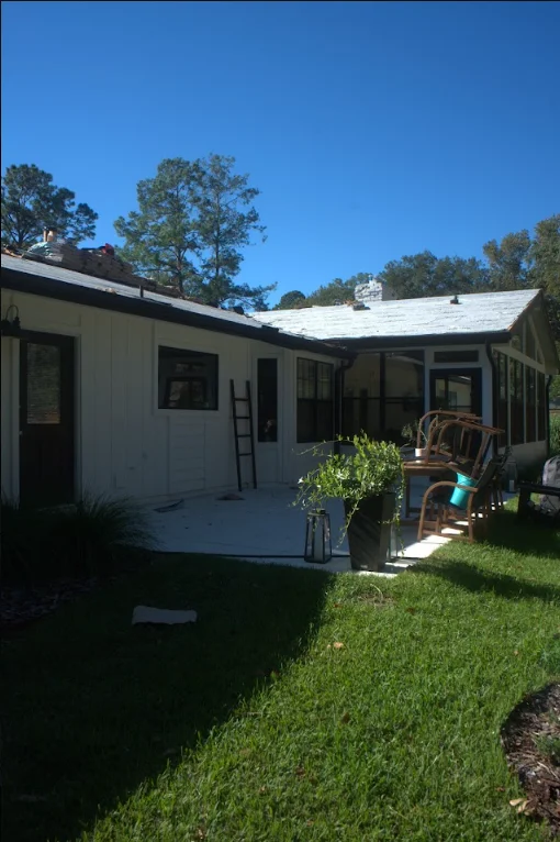 White metal roof on residential home with clear blue sky and mature trees