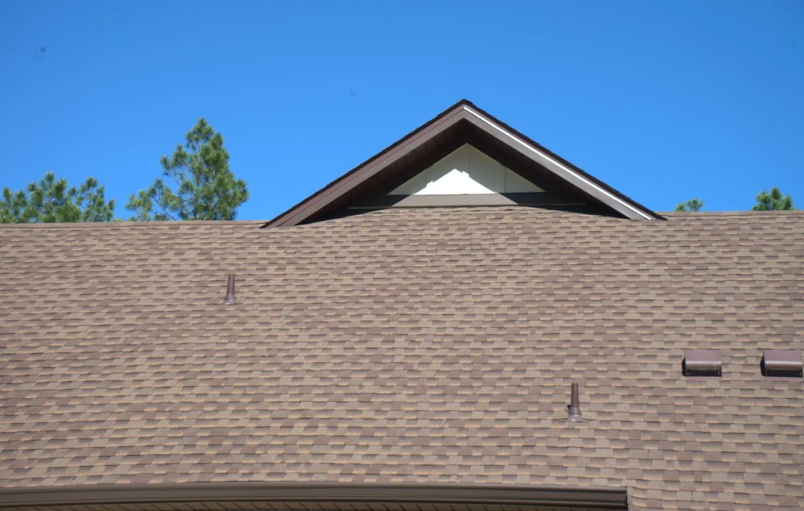 New architectural shingle roof with gray tones and gable vent on residential home