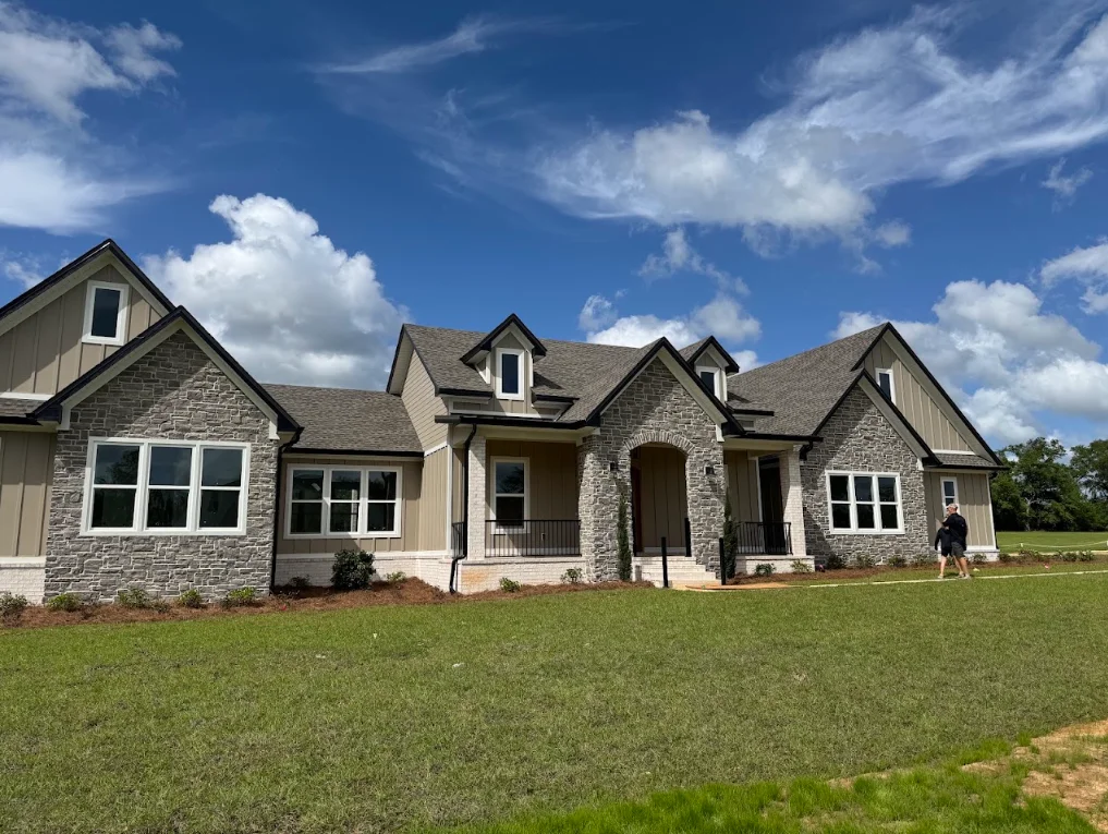 New residential home with gray architectural shingle roof and stone facade in Tallahassee