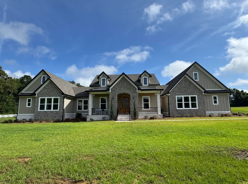 Multi-story residential home with gray stone exterior and new architectural shingle roof installation